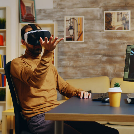 Home 26 game developer with virtual reality headset doing hand gesture while creating new graphics game small