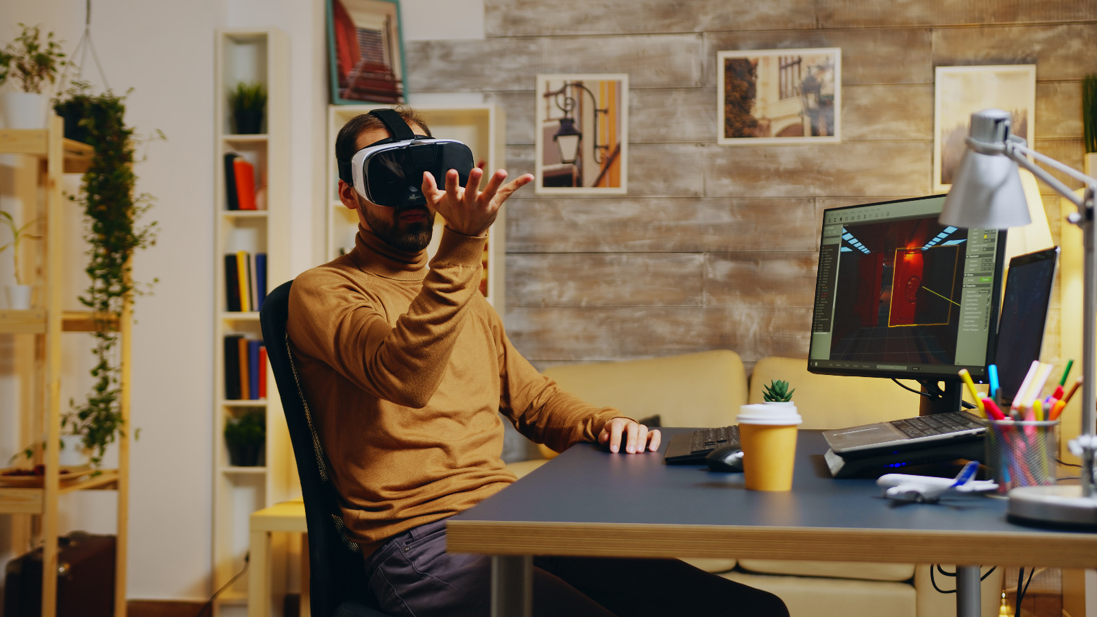 Multimedia 1 game developer with virtual reality headset doing hand gesture while creating new graphics game small